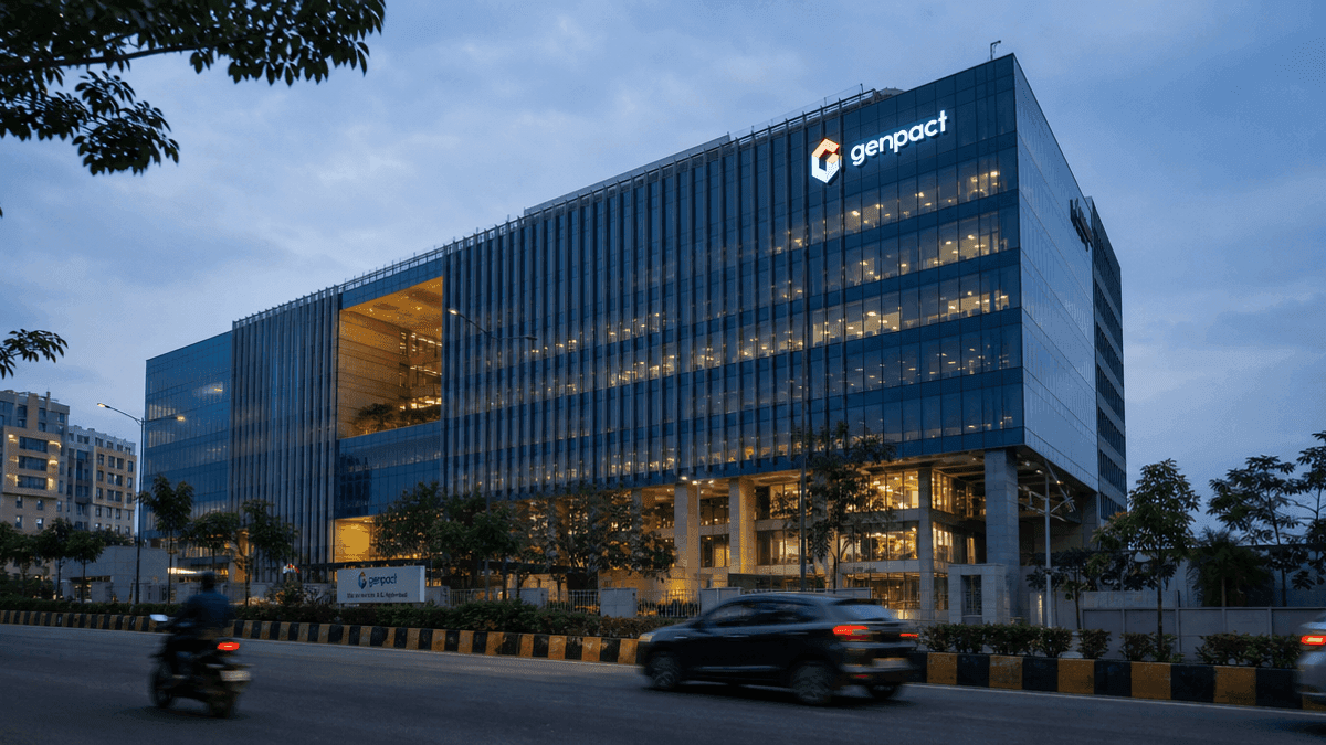 Exterior view of a modern glass office building at dusk, representing the Genpact facility under investigation.