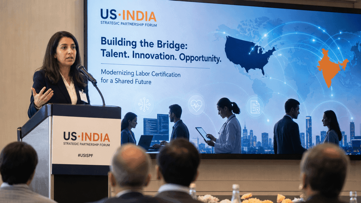 A professional speaking at a podium with a US-India Strategic Partnership Forum logo displayed on a screen behind them.
