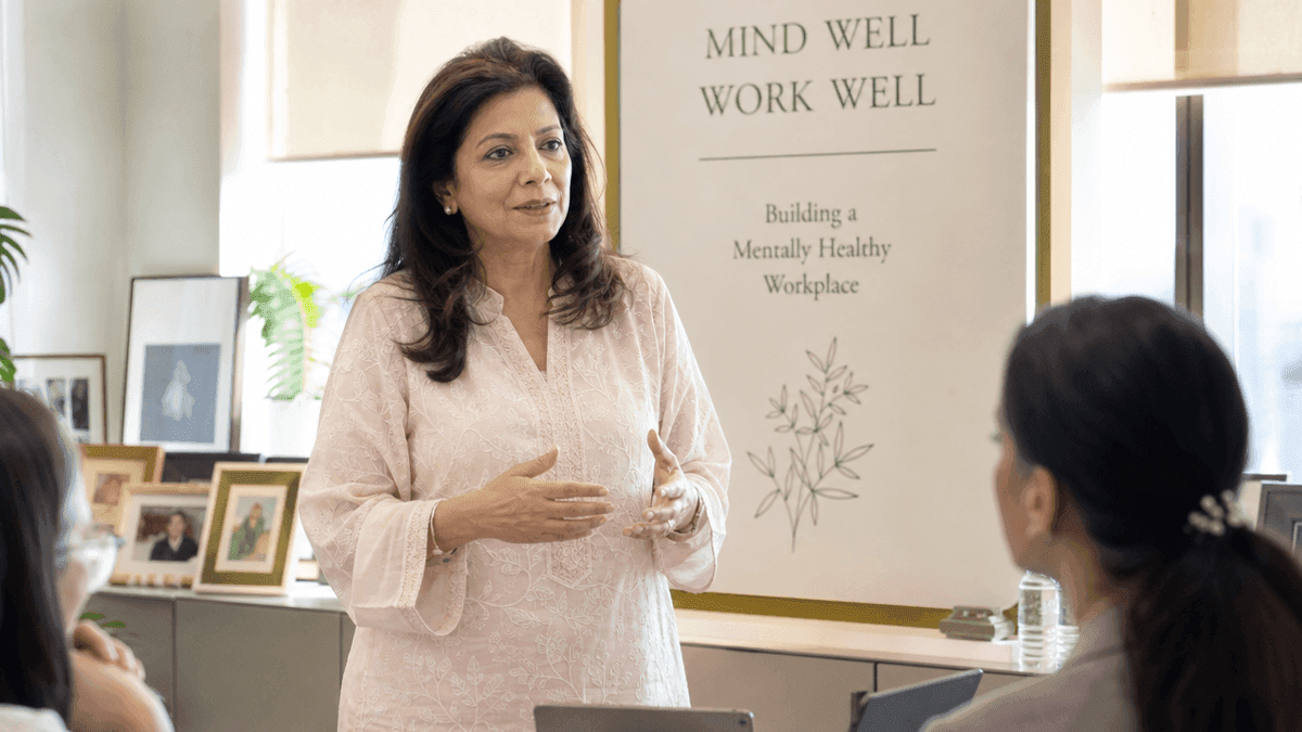 Neerja Birla stands in an office, speaking, representing health advocacy in India.