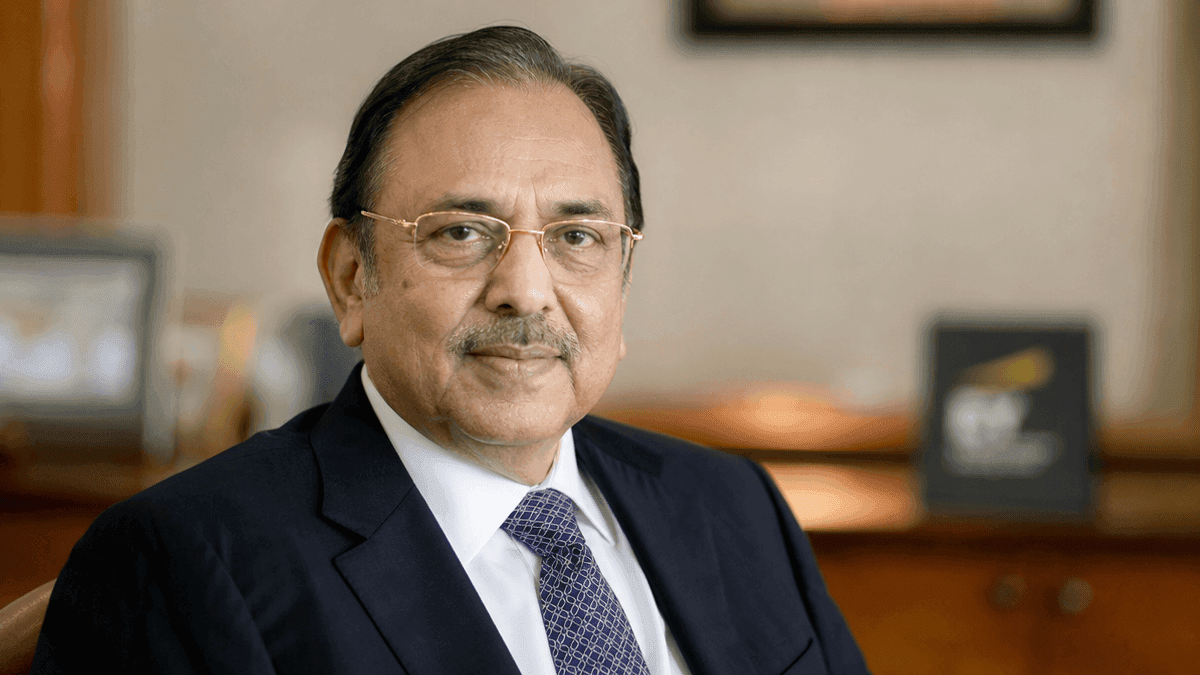 A portrait of Kashi Nath Memani wearing a suit and tie, looking towards the camera against a blurred office background.
